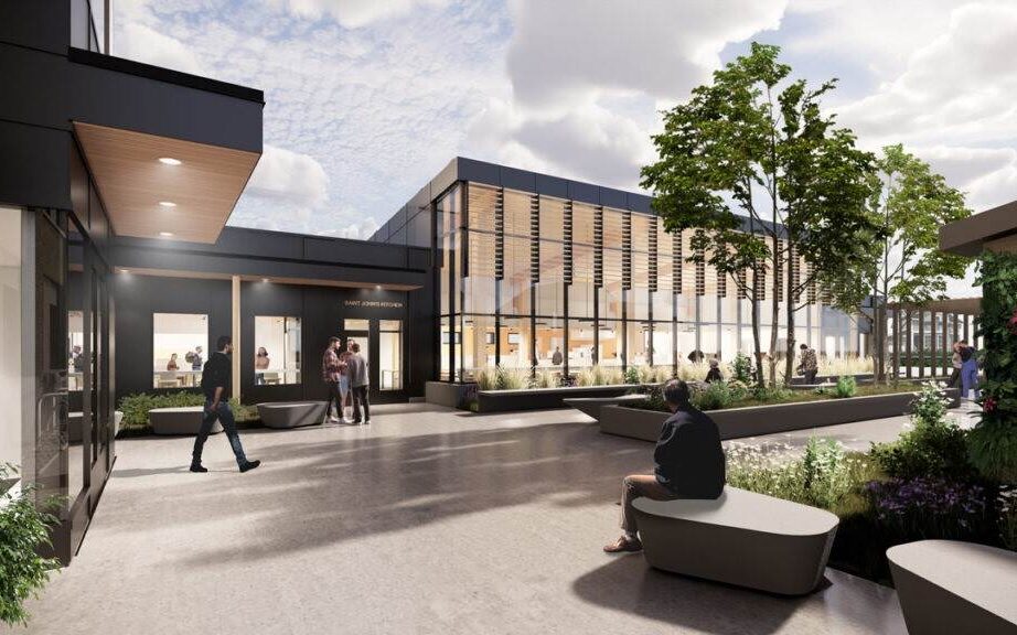 Computer generated image of the proposed new Saint John's Kitchen building viewed from outdoor courtyard. Image show large window exterior wall, trees, bushes, and public benches.
